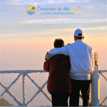 old couple hugging looking out over beach sunset