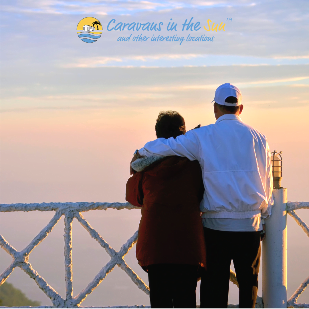 old couple hugging looking out over beach sunset